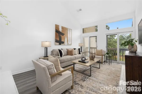 a living room with furniture a large window and a rug