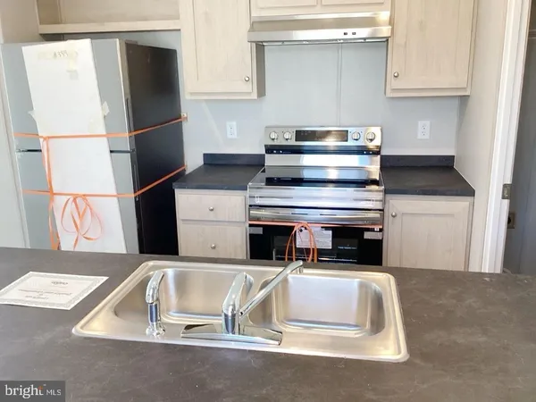 a kitchen with a refrigerator sink and cabinets