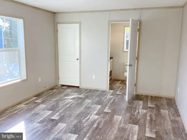 a view of a room with wooden floor and a bathroom