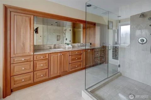 a bathroom with a granite countertop shower a sink and a mirror