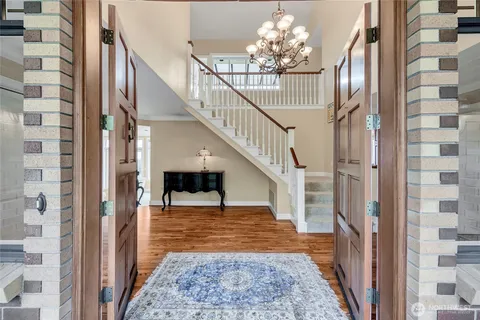 a view of a hallway with wooden floor and stair