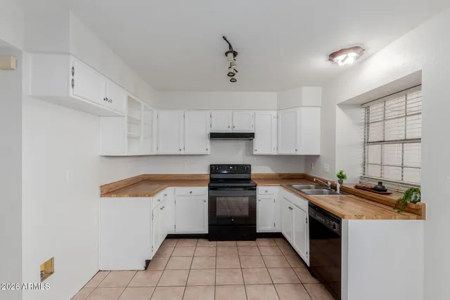 a kitchen with a refrigerator a stove top oven and a window