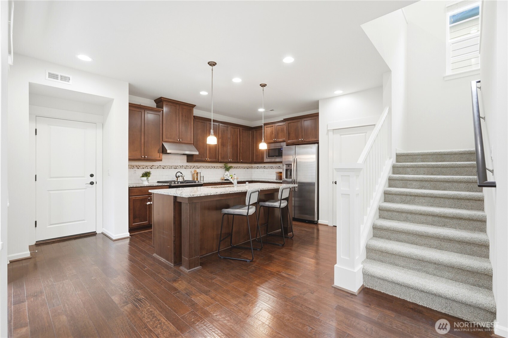 4413 185th Place Southeast Bothell, WA 98012 - Photo 12 of 40 a kitchen with stainless steel appliances kitchen island wooden floors granite counter tops and a window