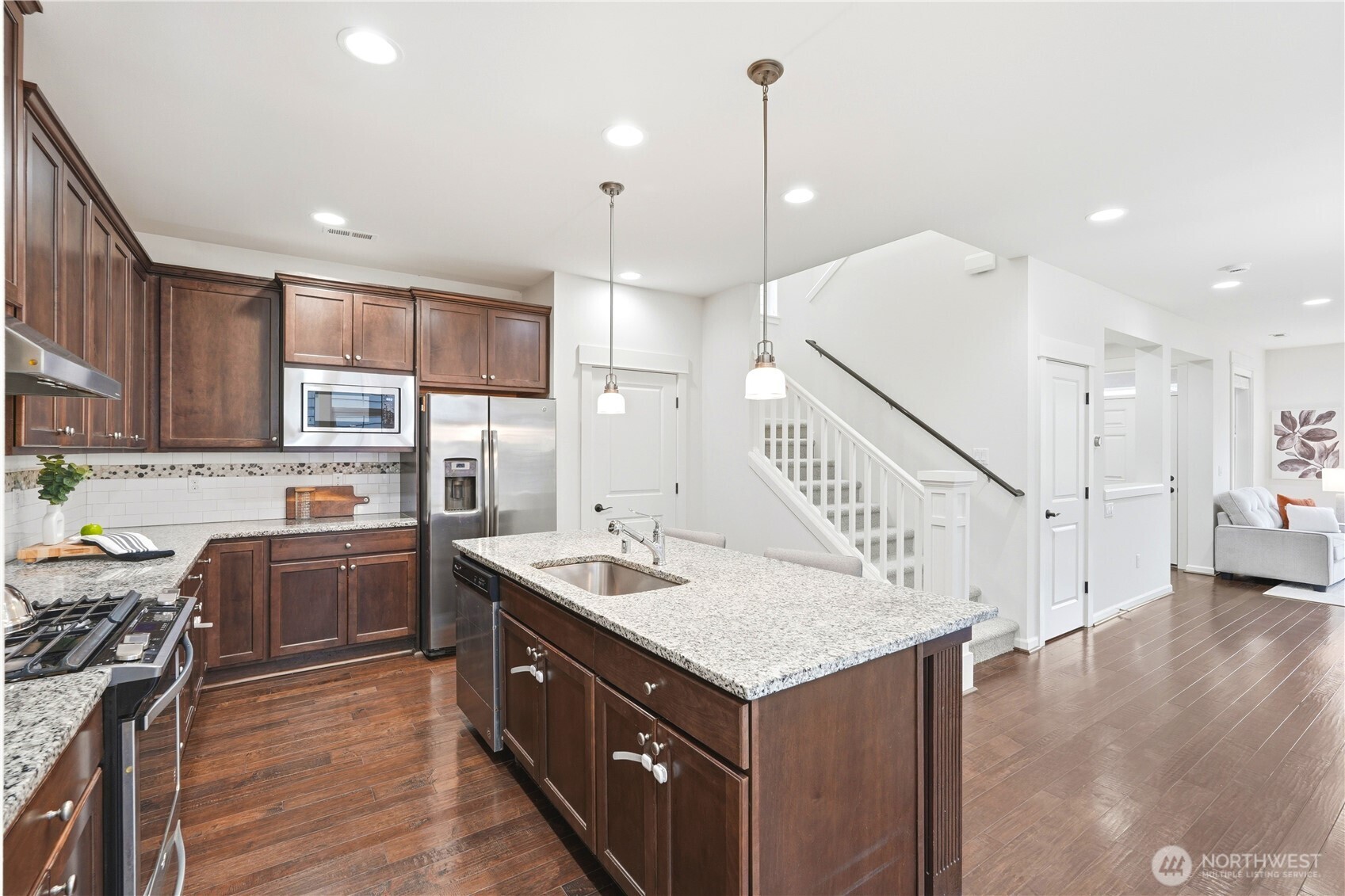 4413 185th Place Southeast Bothell, WA 98012 - Photo 14 of 40 a kitchen with a stove a sink a refrigerator and a wooden floor