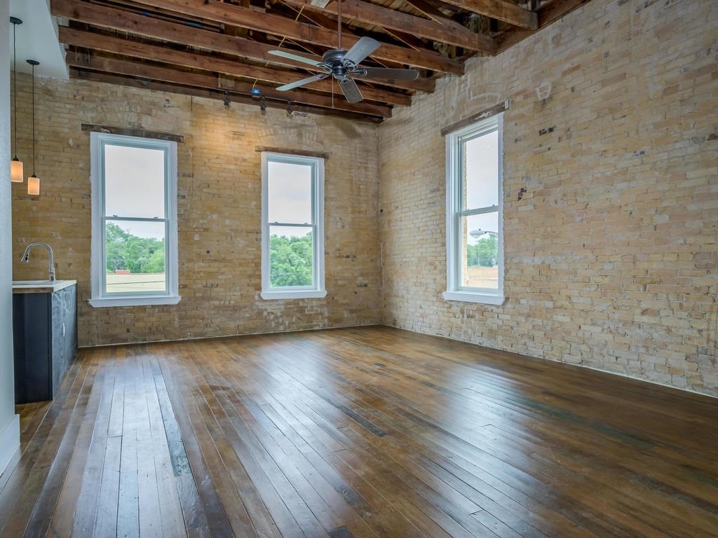110 South Main Street, Unit 206 Elgin, TX 78621 - Photo 2 of 20 an empty room with wooden floor and windows