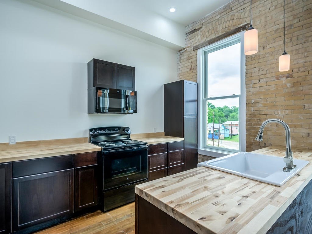 110 South Main Street, Unit 206 Elgin, TX 78621 - Photo 6 of 20 a kitchen with a stove and a sink