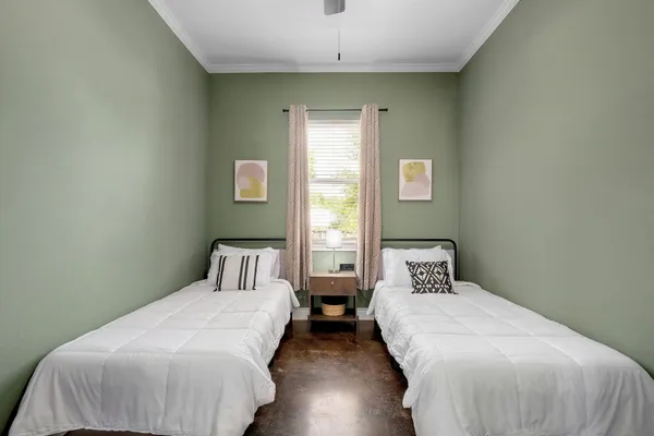 a bedroom with two beds and a window