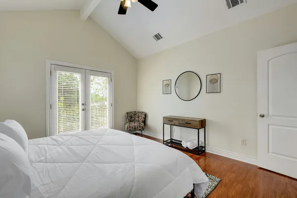 a bedroom with a bed a mirror and a window