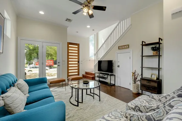 a living room with furniture a ceiling fan and a flat screen tv
