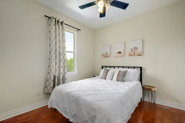 a bed sitting in a bedroom next to a window and a chandelier