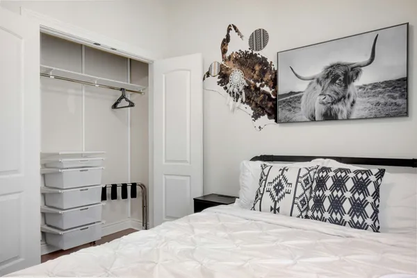 a bedroom with a bed and a painting on the wall