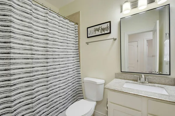 a bathroom with a granite countertop toilet and sink