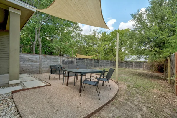 a view of a patio with table and chairs with wooden floor and fence
