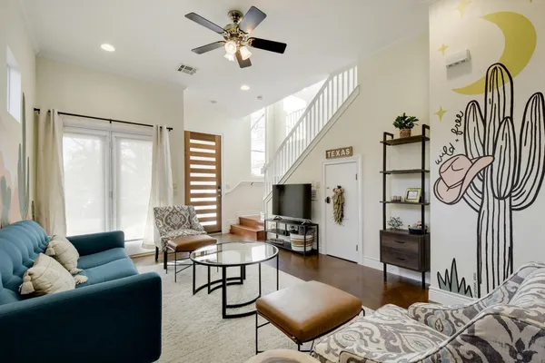 a living room with furniture a flat screen tv and a window