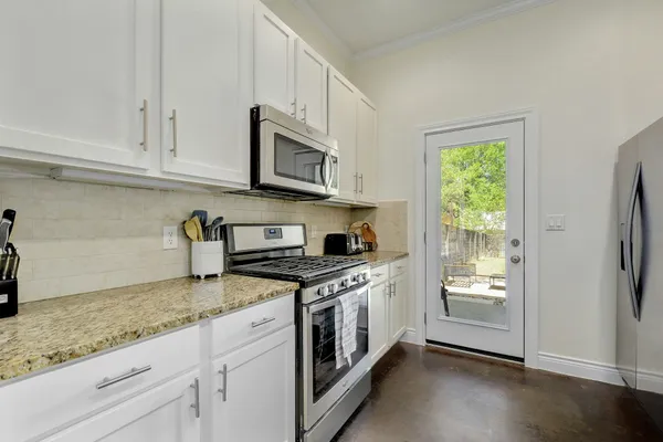 a kitchen with stainless steel appliances granite countertop a stove a sink and a refrigerator