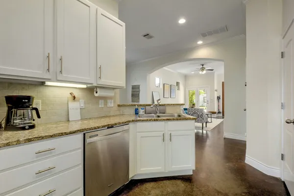 a kitchen with granite countertop a sink a stove and cabinets
