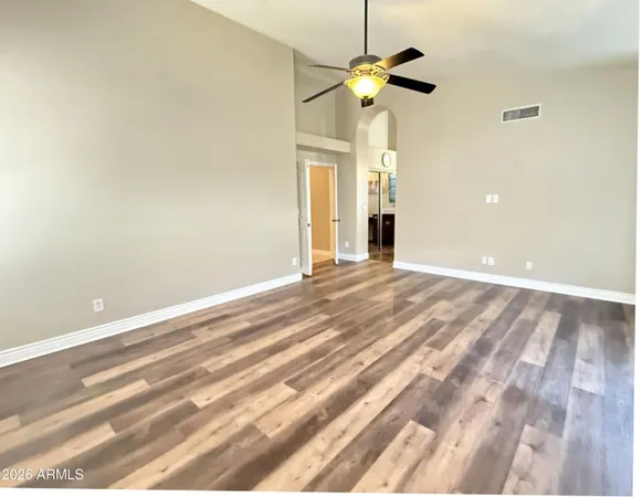 a view of an empty room with a chandelier fan