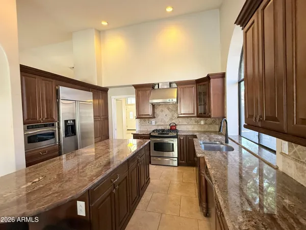 a kitchen with granite countertop a stove a sink and dishwasher
