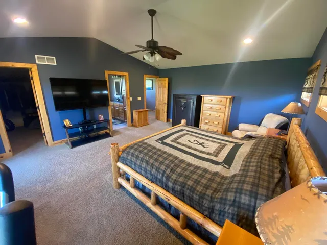 a bedroom with bed and a flat tv screen on dresser