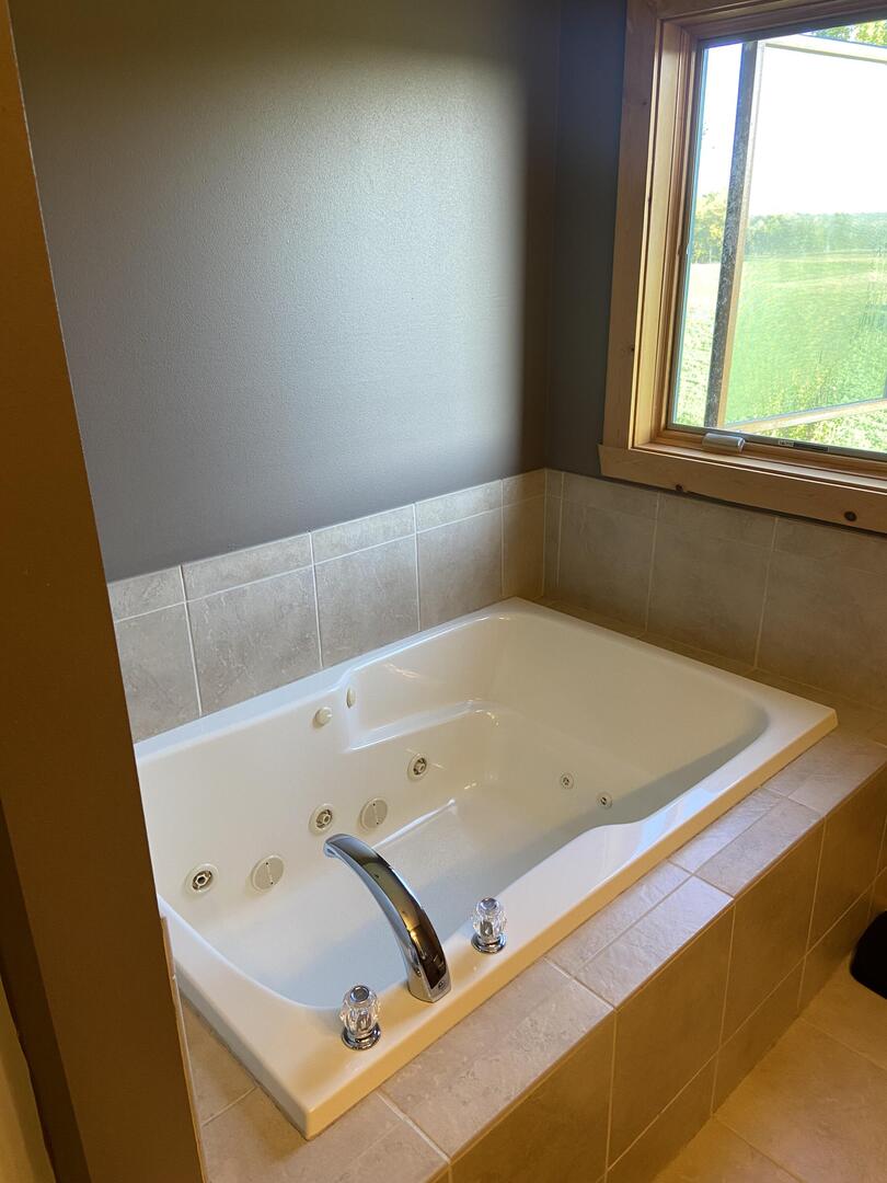 7330 North Crestview Road Stillman Valley, IL 61084 - Photo 15 of 33 a bathroom with a tub and large window