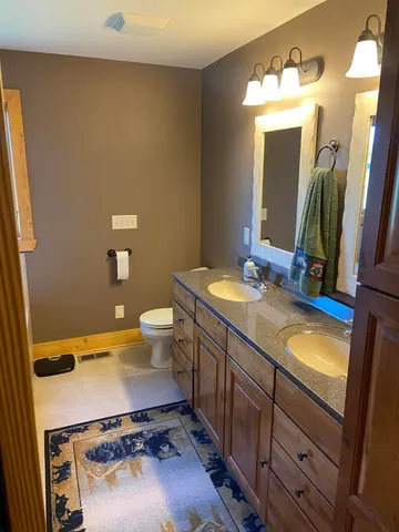 a bathroom with a sink mirror and toilet