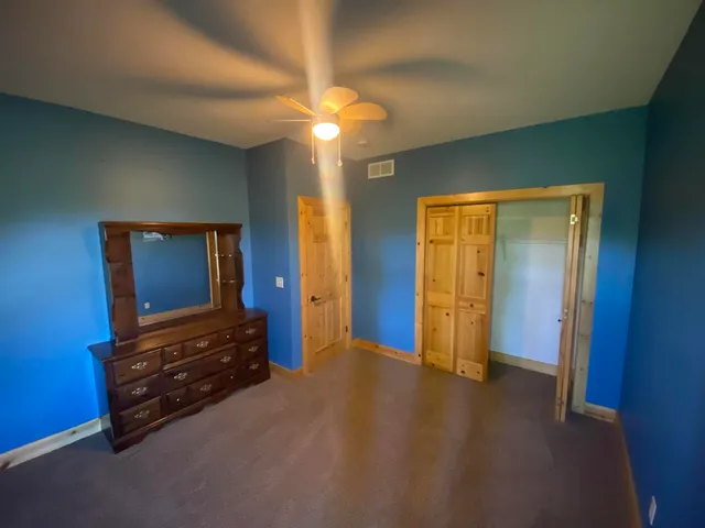 a view of an empty room with closet and wooden floor