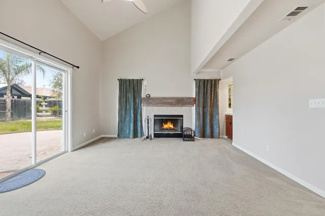 a view of an empty room with a fireplace and a window