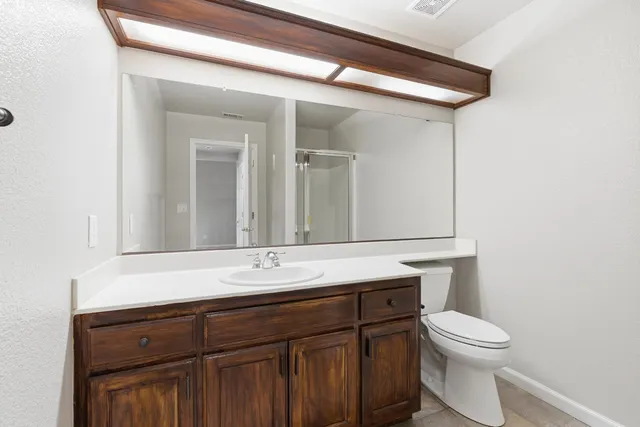 a bathroom with a sink a toilet and mirror