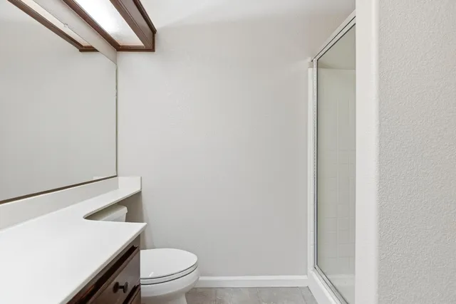 a bathroom with a granite countertop white toilet and a sink