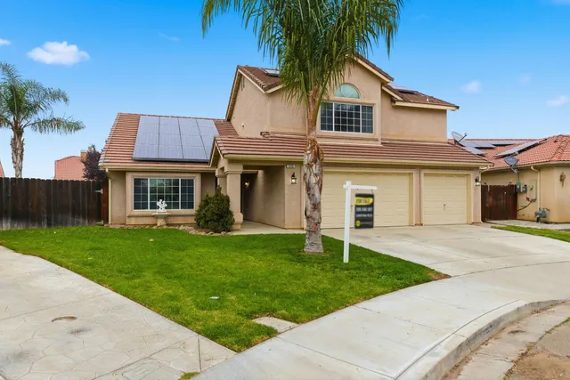 a front view of a house with a garden and yard