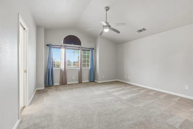an empty room with closet and a ceiling fan