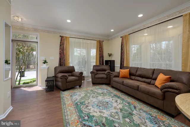 a kitchen with stainless steel appliances granite countertop a stove a refrigerator a kitchen island a dining table and chairs with wooden floor