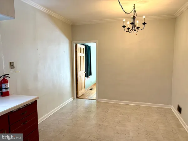 an empty room with a chandelier fan