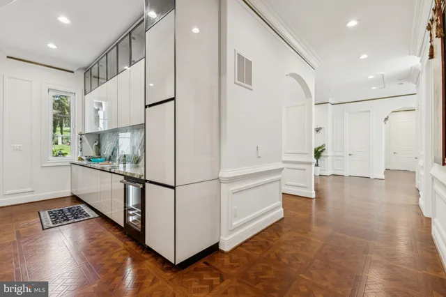 a spacious bathroom with a tub double vanity and view of living room