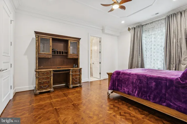 a large bedroom with a bed and wooden floor