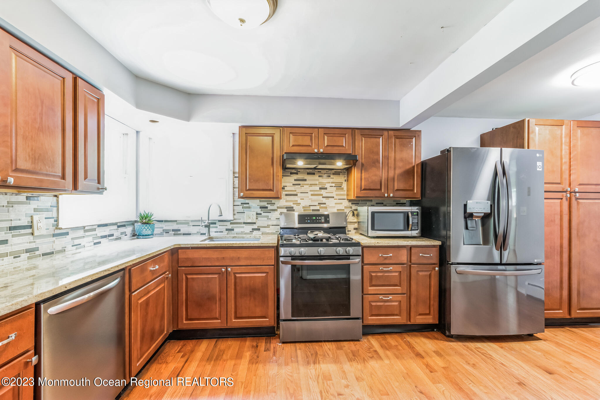 420 Leming Road Jackson, NJ 08527 - Photo 10 of 30 a kitchen with wooden floors stainless steel appliances a sink and a window
