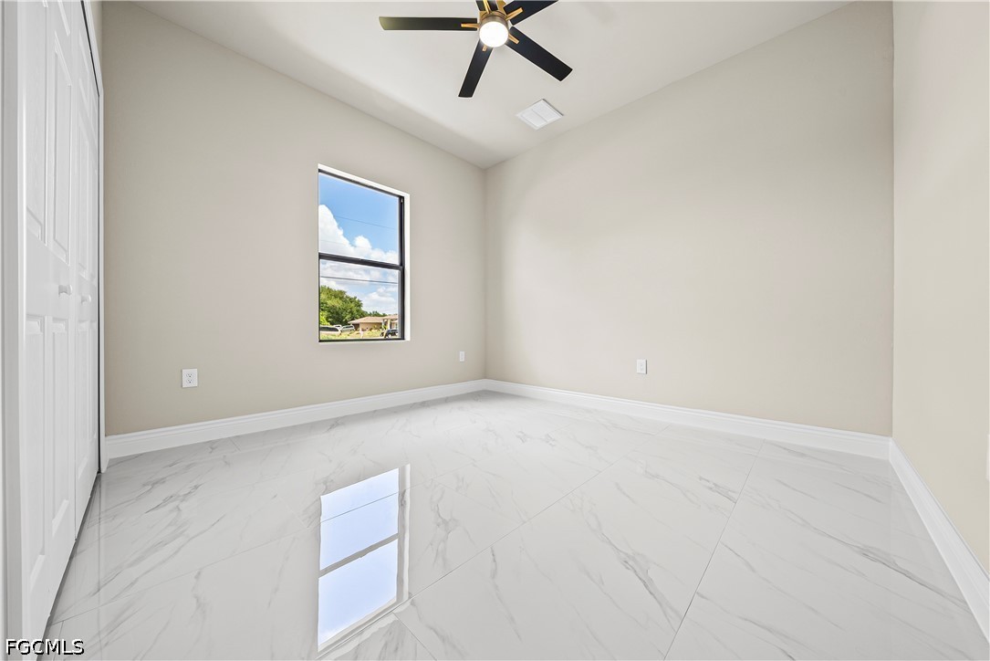 2919 9th Street Southwest Lehigh Acres, FL 33976 - Photo 11 of 29 an empty room with windows and ceiling fan