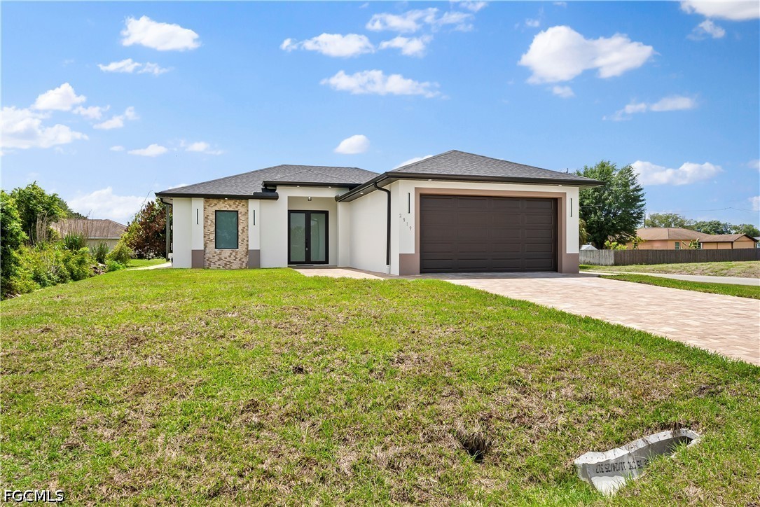 2919 9th Street Southwest Lehigh Acres, FL 33976 - Photo 23 of 29 a front view of a house with yard and large tree