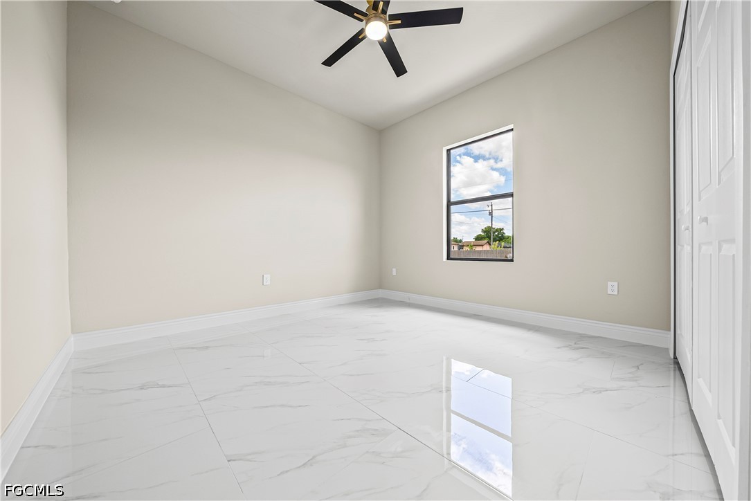 2919 9th Street Southwest Lehigh Acres, FL 33976 - Photo 9 of 29 an empty room with windows and ceiling fan