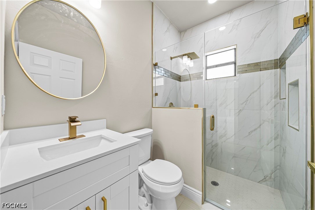2919 9th Street Southwest Lehigh Acres, FL 33976 - Photo 10 of 29 a bathroom with a sink toilet and a mirror