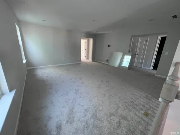 a view of an empty room with a fireplace and a window