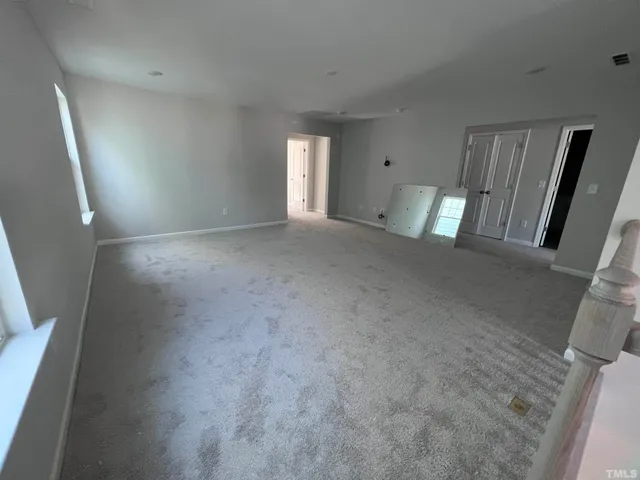 a view of an empty room with a fireplace and a window