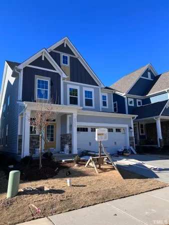 a front view of a house with yard and parking space