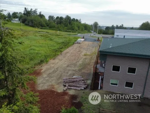 a view of a street with big yard and large trees