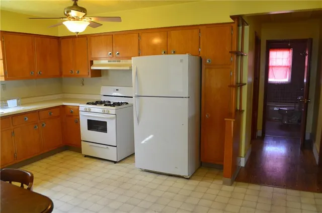 a white refrigerator freezer and a stove sitting inside of a kitchen
