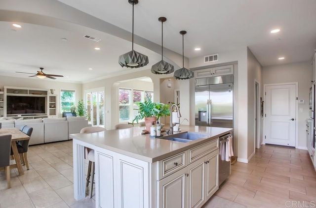 a kitchen with stainless steel appliances granite countertop a sink a stove and a refrigerator