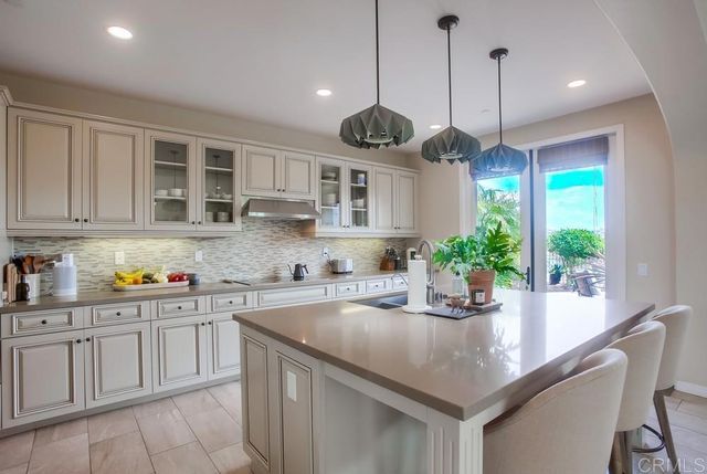 a kitchen with stainless steel appliances granite countertop a stove a sink a center island and cabinets