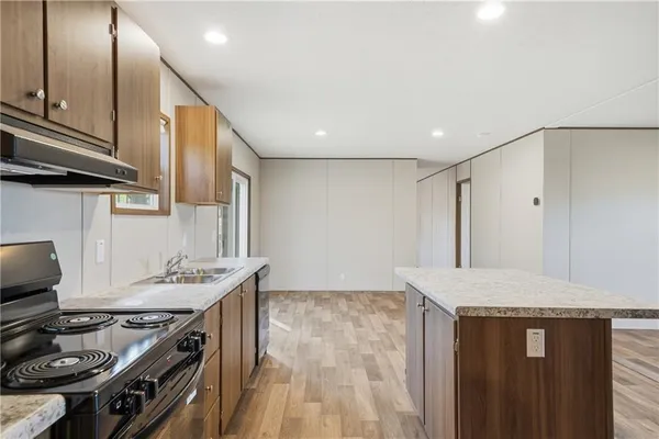 a kitchen with stainless steel appliances granite countertop a sink stove and cabinets