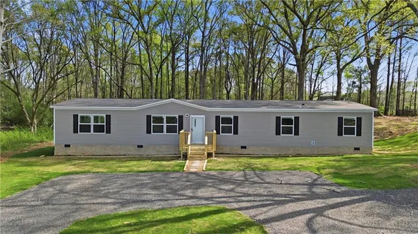 a view of a yard in front of a house with large trees