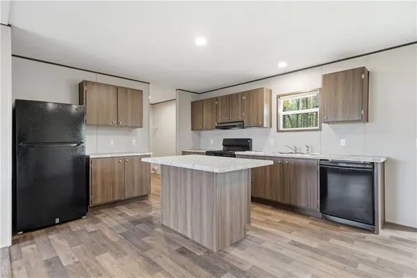 a kitchen with granite countertop a refrigerator stove top oven and sink